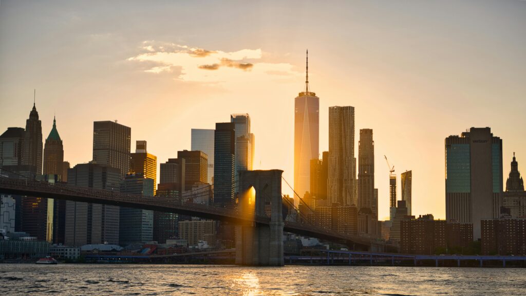 Stunning view of New York City's skyline at sunset featuring the iconic Brooklyn Bridge.